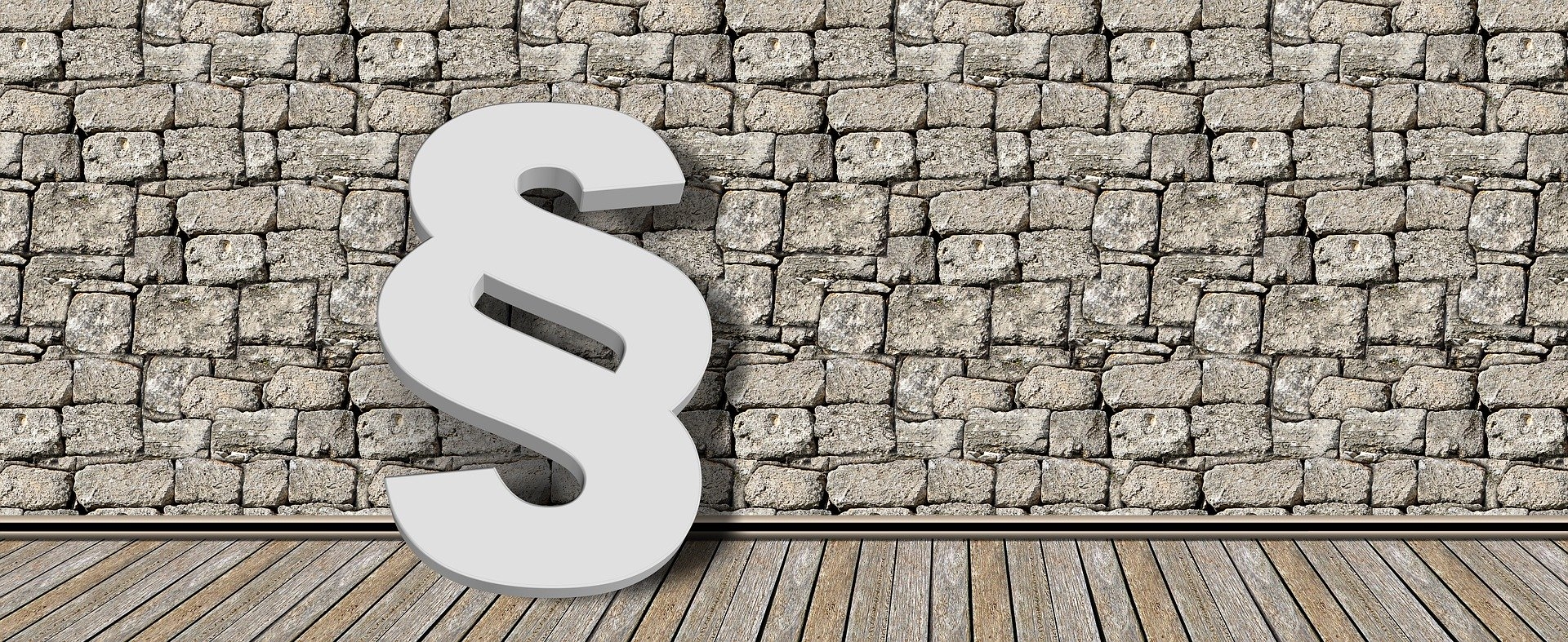 Ein Paragraphenzeichen vor einer Wand.