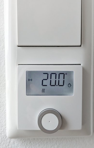 Digitales Thermometer an der Heizung zeigt 20 Grad