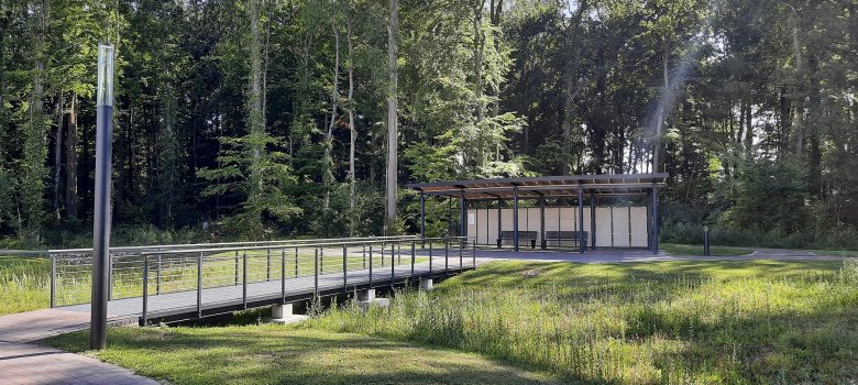 Eine Fußgängerbrücke und ein Unterstand mit zwei Bänken im Mariengarten Ahaus