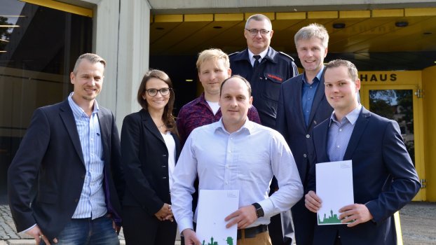 zu sehen sind Feuerwehrbedienstete mit Urkunden und Zivilisten