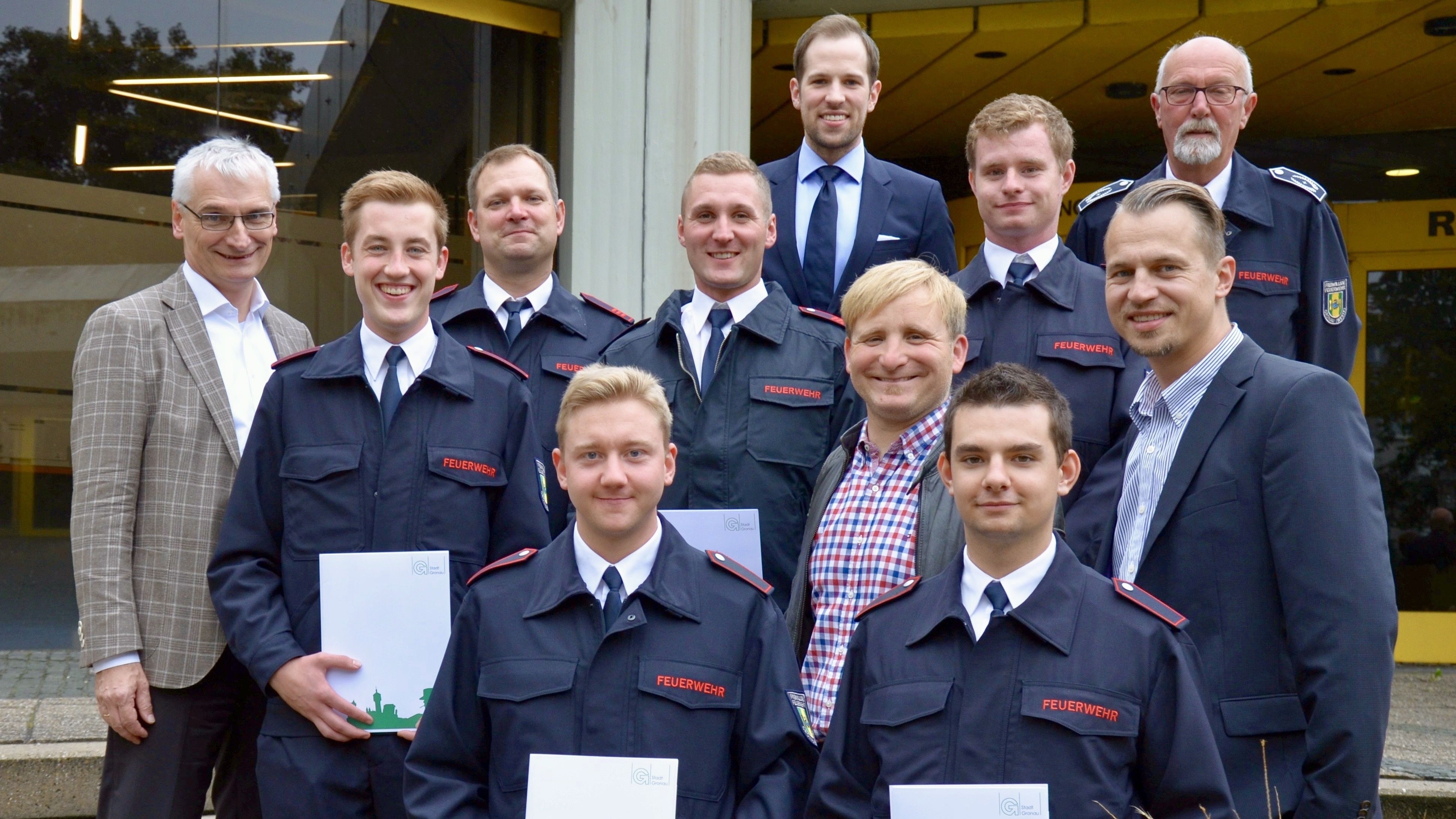zu sehen sind Feuerwehrbedienstete mit Urkunden und Zivilisten