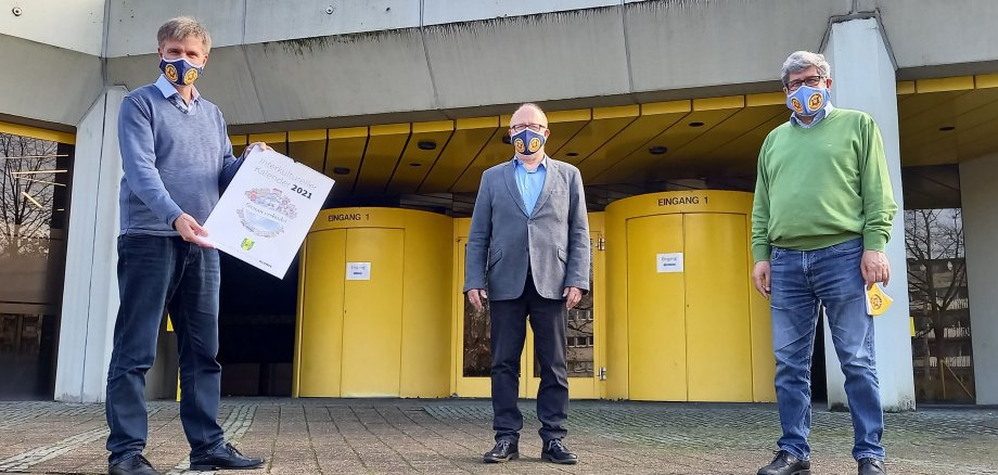 Sie sehen Bürgermeister Rainer Doetkotte, Norbert Lüttmann und Ahmet Sezer vor dem Rathaus