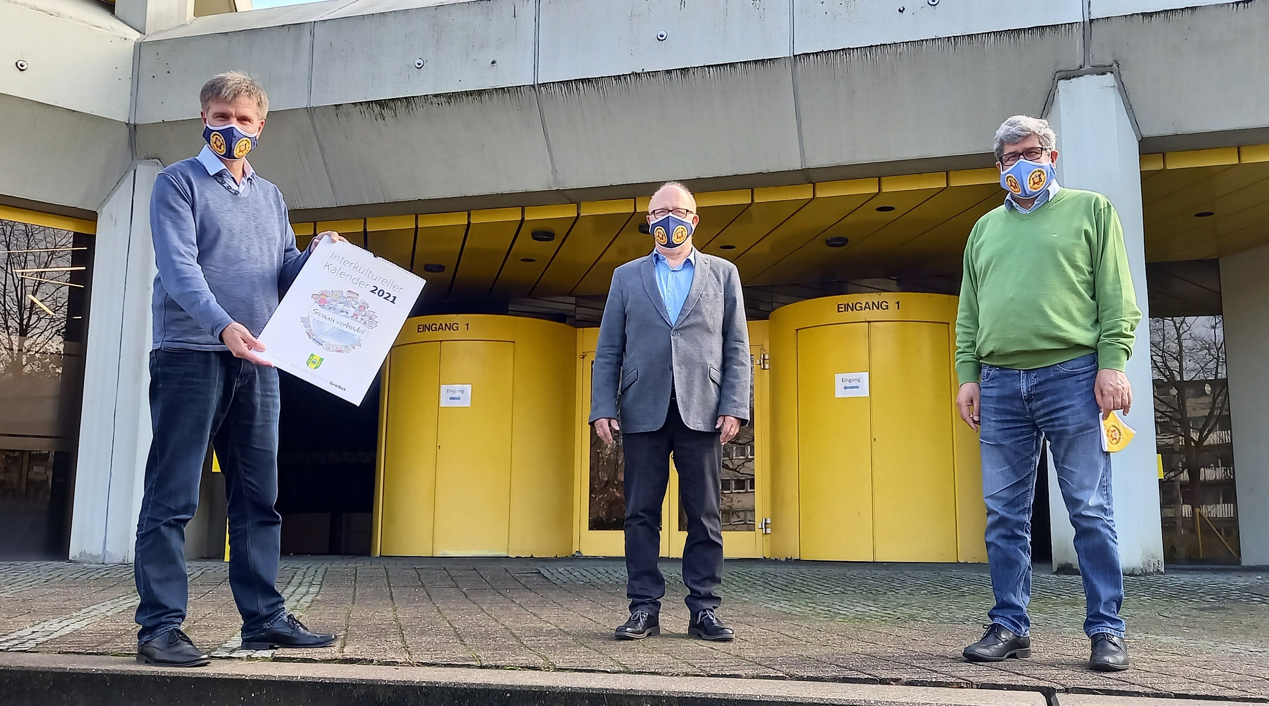 Sie sehen Bürgermeister Rainer Doetkotte, Norbert Lüttmann und Ahmet Sezer vor dem Rathaus