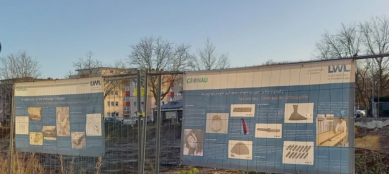 Sie sehen zwei Banner an einem Bauzaun am ehemaligen Hertie-Gelände