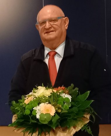 Sie sehen den 2. Stellvertreter des Bürgermeisters Werner Bajorath mit Blumenstrauß