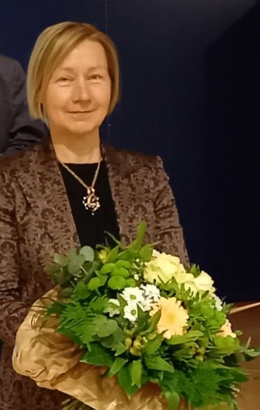 Sie sehen die 1. Stellvertreterin des Bürgermeisters Birgit Tegetmeyer mit Blumenstrauß