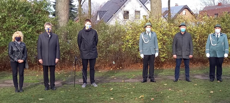 Sie sehen ein Gruppe von Menschen am Ehrenmal