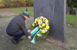 Sie sehen einen Mann bei der Kranzniederlegung