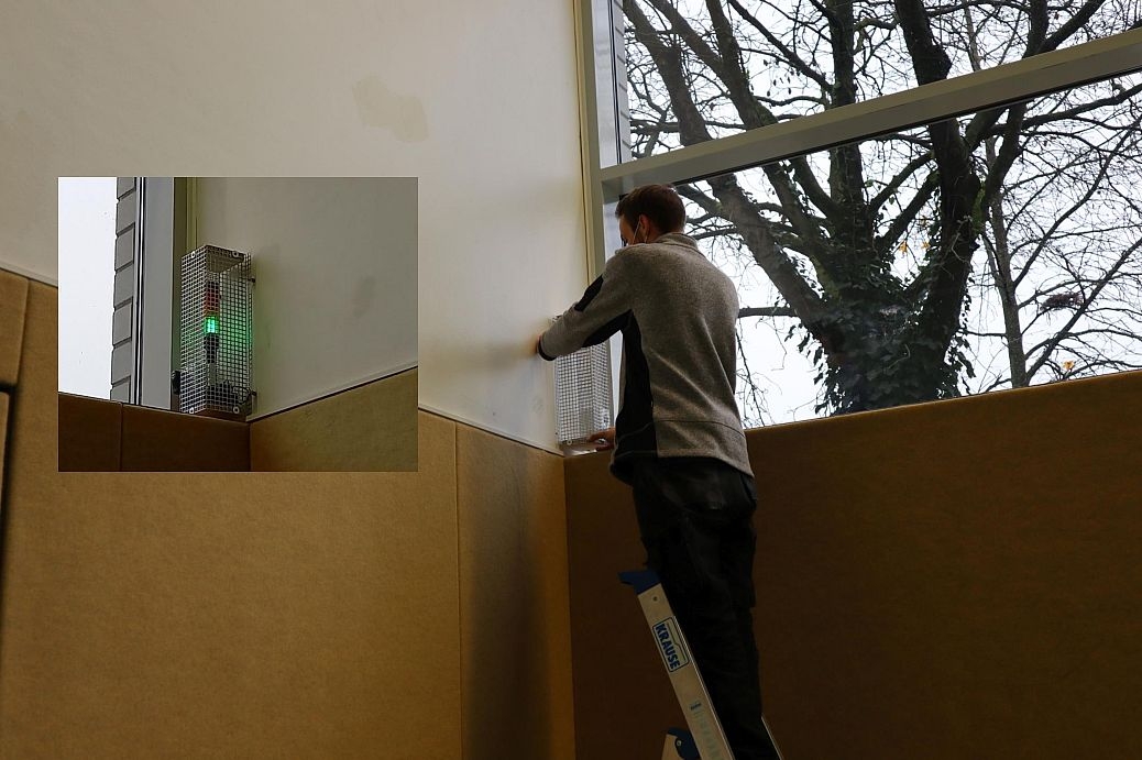 Sie sehen eine CO2-Ampel und einen Arbeiter bei der Installation