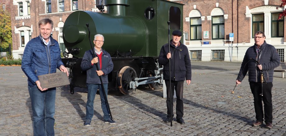 Gruppe Menschen vor der Dampfspeicherlok am Bahnhof