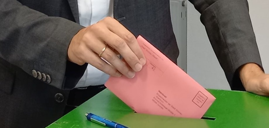 Wahlurne mit Briefwahlumschlag
