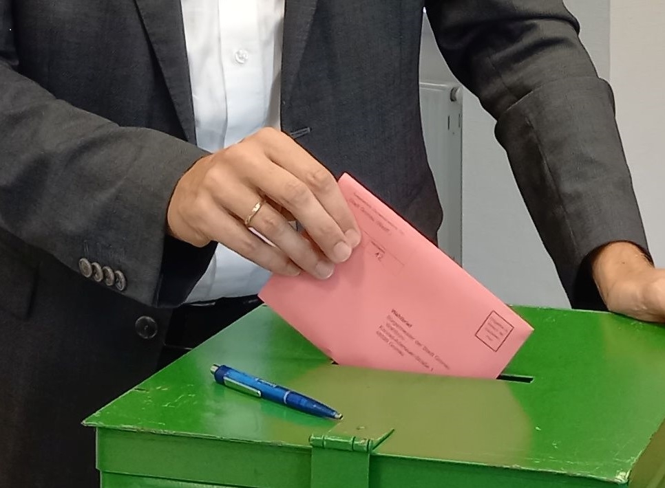 Wahlurne mit Briefwahlumschlag