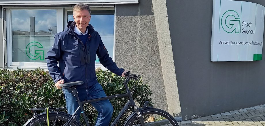 Der Bürgermeister Rainer Doetkotte steht mit seinem Fahrrad vor dem Verwaltungsgebäude am Jöbkesweg.