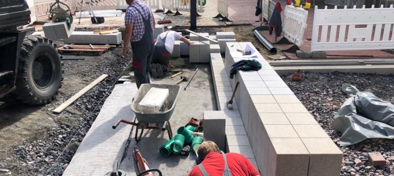 Zwei Mitarbeiter setzen die Steine für den Gronaubrunnen. 