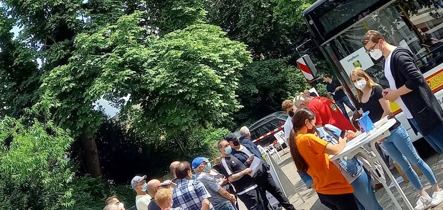Mehrere Personen stehen an, um sich im Impfbus impfen zu lassen.