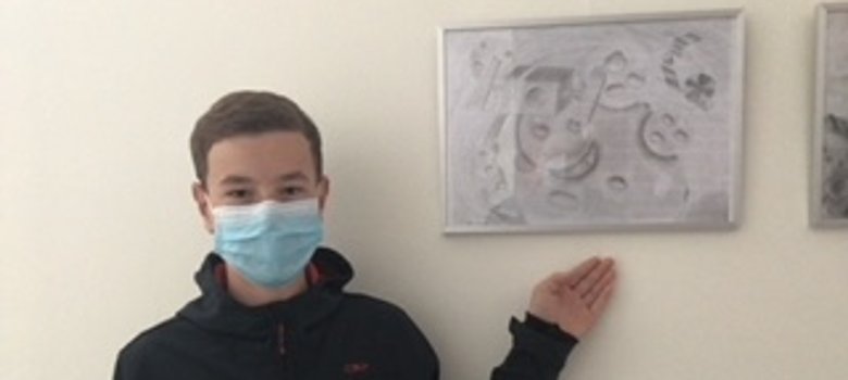 Der Schüler Felix vor seinem Bild.