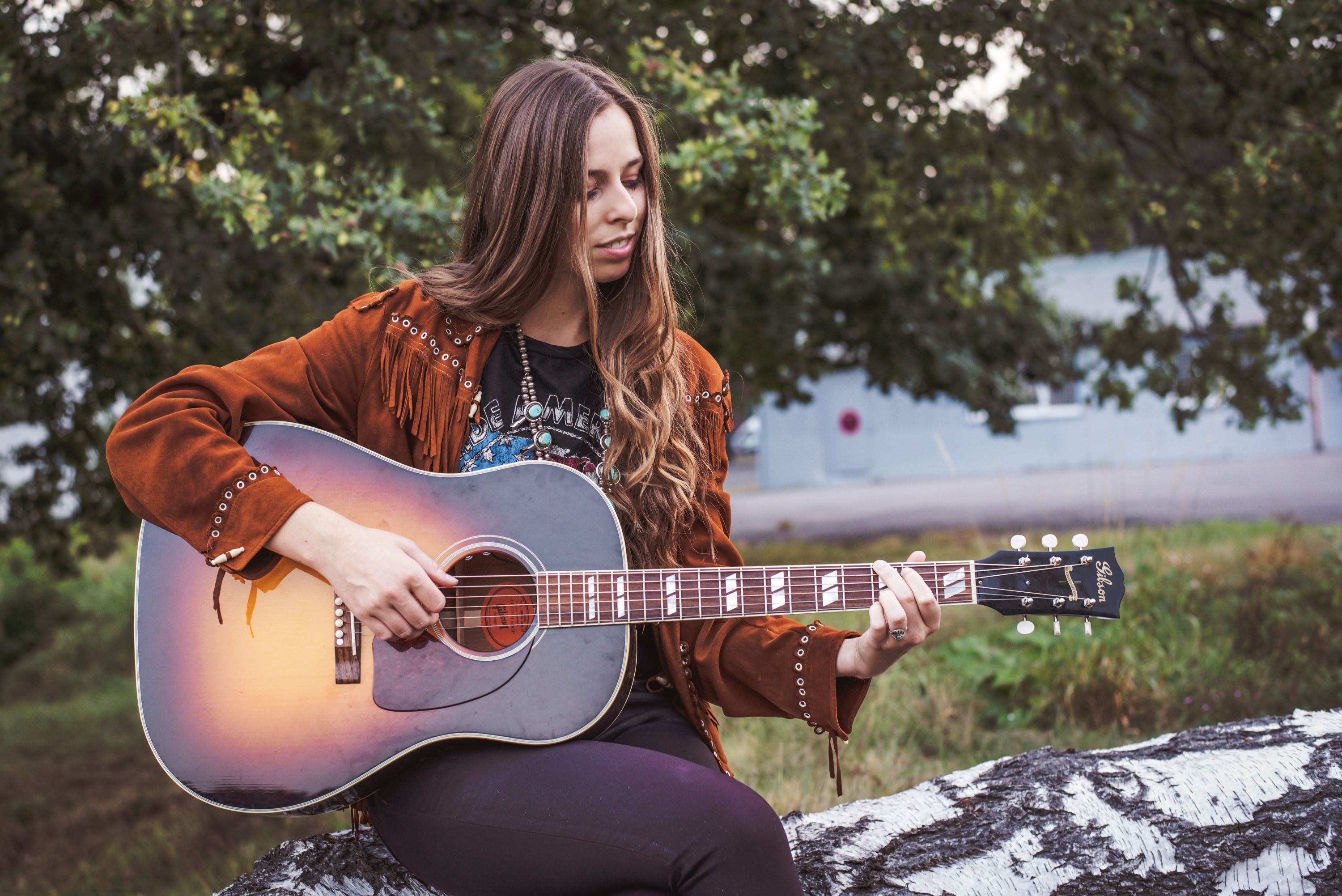 Die Musikerin DanaMaria spielt auf einer Gitarre.