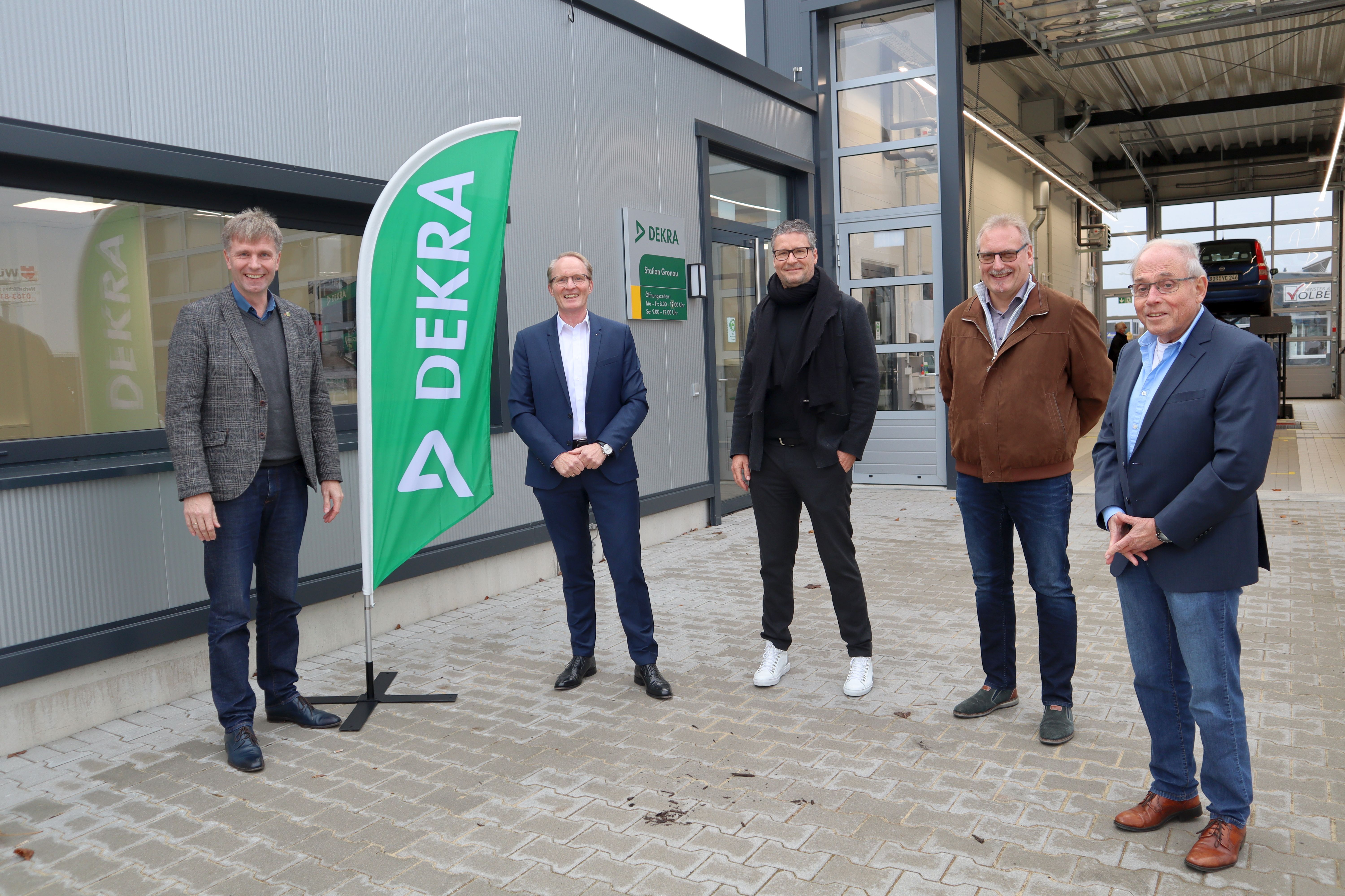 Eine Gruppe von fünf Männern und die Fahne der DEKRA