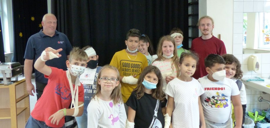 Die Gruppe der Grundschulkinder mit Herrn Vocke vom DRK, hinten 1. von links, und Sprachlernbegleiter Eamon Nethe, hintere Reihe, rechts.