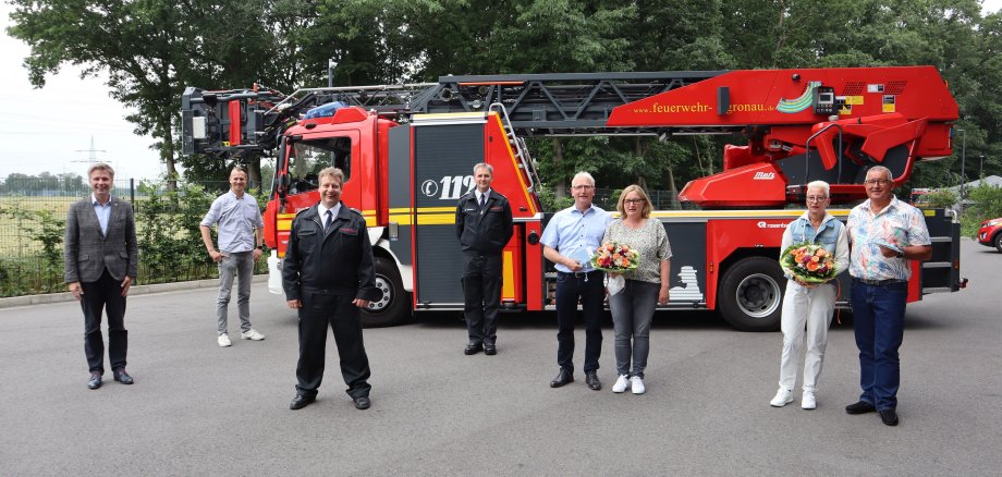 Menschengruppe vor einem Feuerwehrwagen