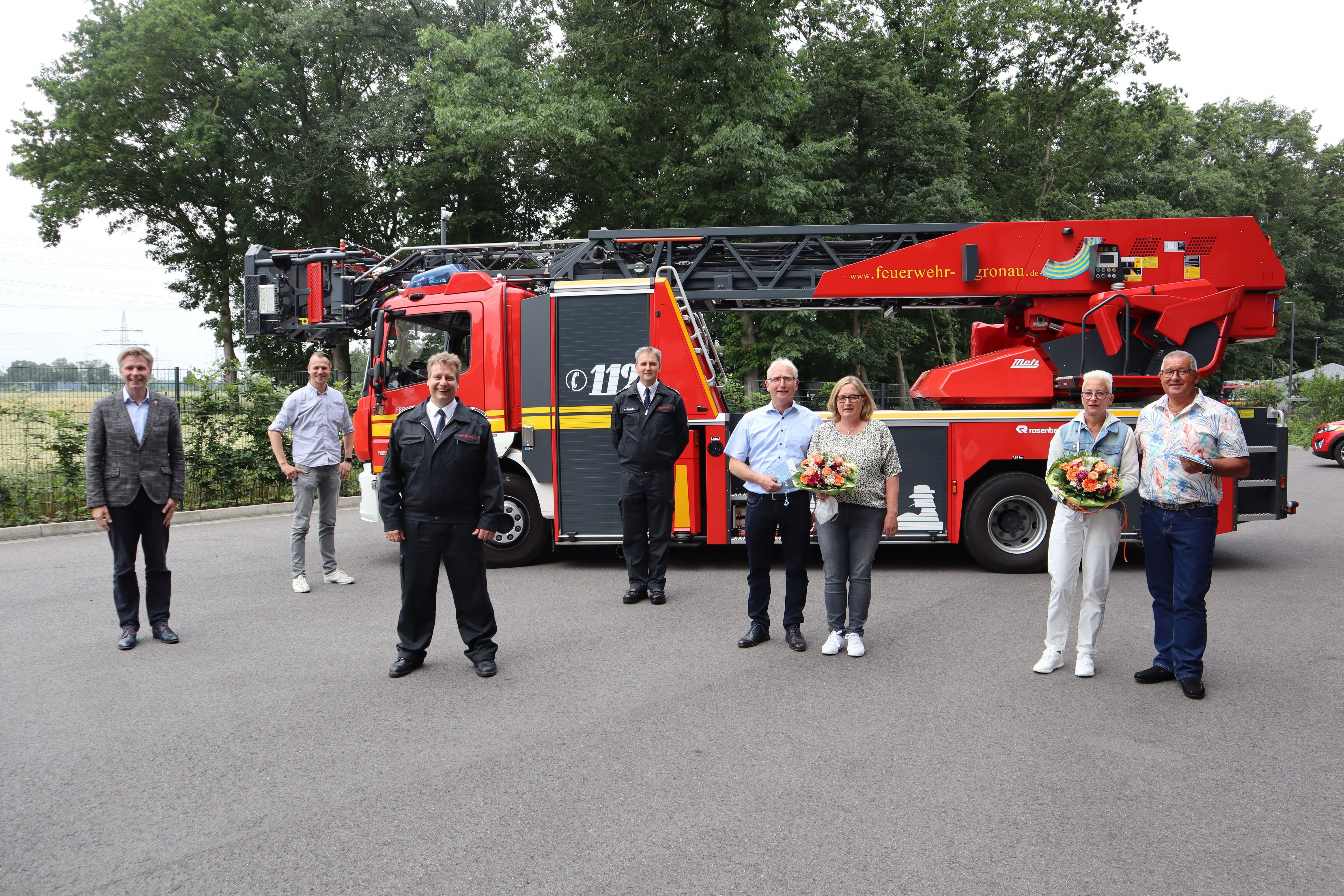 Menschengruppe vor einem Feuerwehrwagen