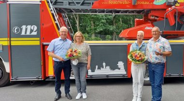 Menschen vor einem Feuerwehrfahrzeug