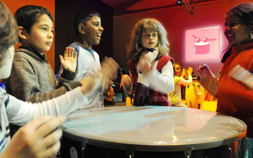 Kinder, die an einer großen Trommel spielen