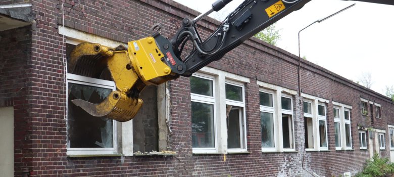 Die Baggerschaufel greif beim Pförtnerhaus in das Fenster.