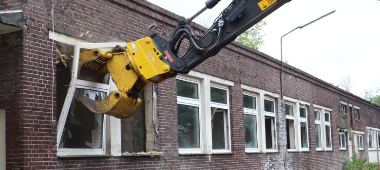 Die Baggerschaufel reißt beim Pförtnerhaus das Fenster heraus.