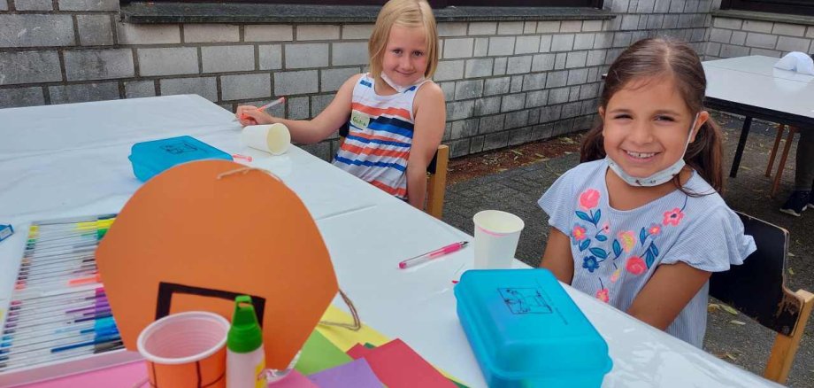 Emilia und Nalan basteln einen kleinen Basketball-Korb.