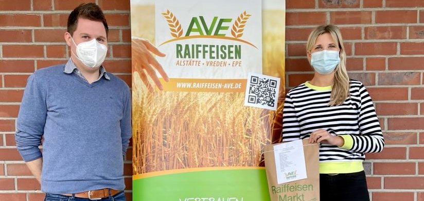 Thomas Kortbuß und Leonie Breuers stehen neben einem Rollup und stellen die Blumensamen vor.