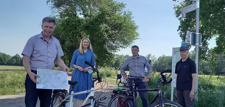 Menschen mit Fahrrädern vor einem Radfahr-Knotenpunkt