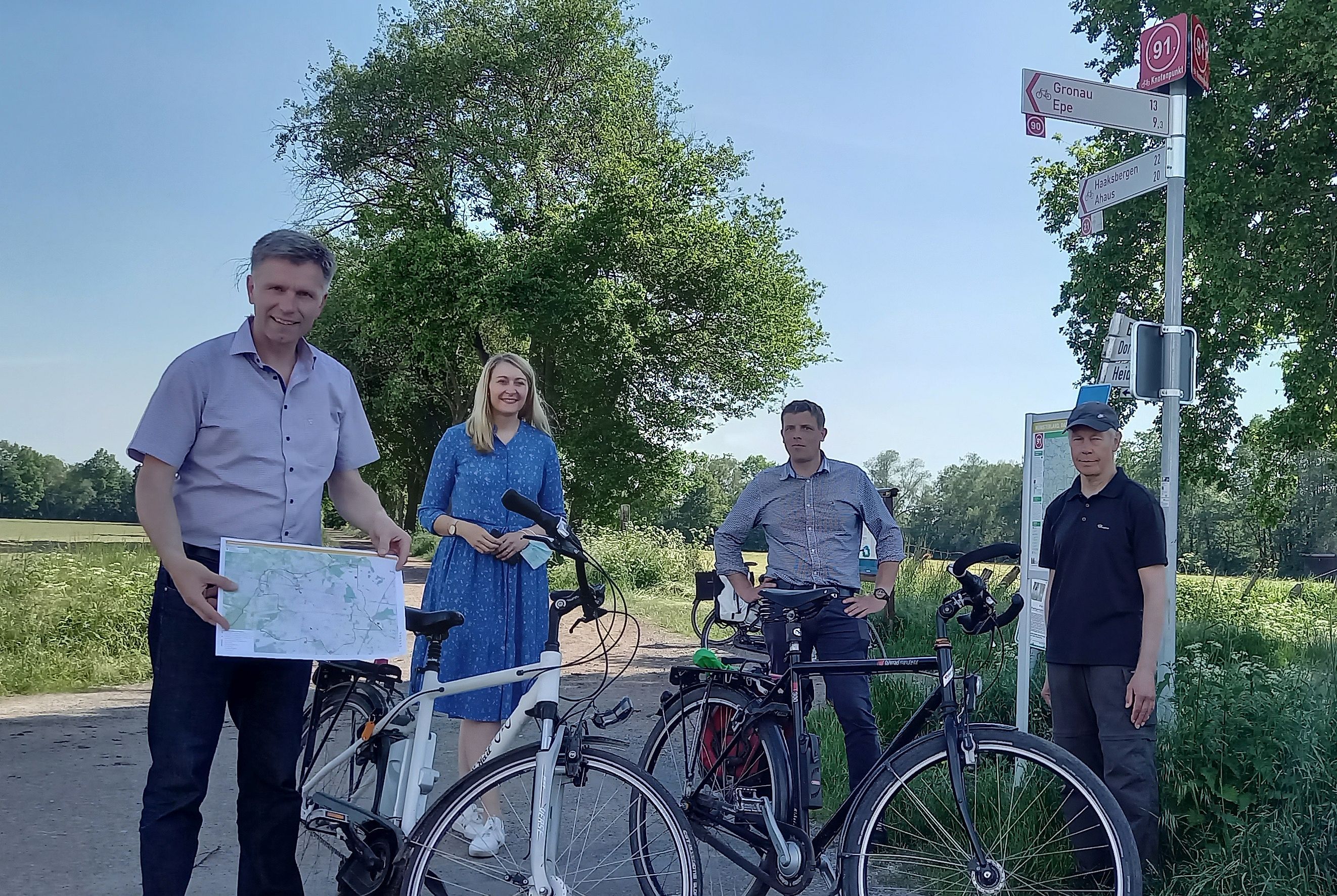 Menschen mit Fahrrädern vor einem Radfahr-Knotenpunkt