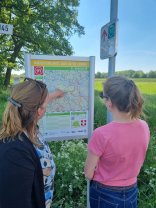 zwei Frauen vor einem Hinweisschild 