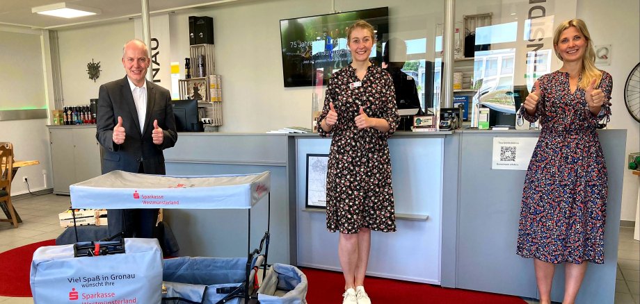 Stefan Nadicksbernd (Sparkasse Westmünsterland), Katharina Detert und Leonie Breuers (beide Stadt- und Tourismusmarketing Gronau) freuen sich über die Bollerwagen.  