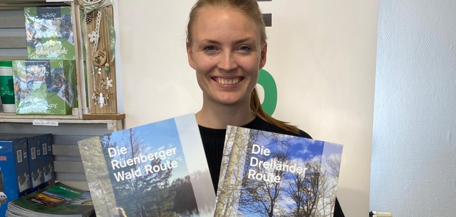 Die Mitarbeiterin des Stadtmarketings Lena Kerkeling hält die beiden neuen Wanderflyer hoch.