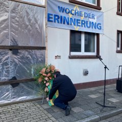 Bürgermeister Rainer Doetkotte kniet vor dem Kranz nieder.