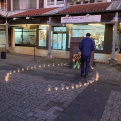 Der Bürgermeister Rainer Doetkotte legt eine Rose am Denkmal nieder.