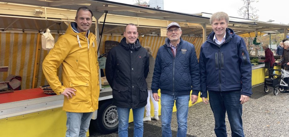 Bürgermeister Rainer Doetkotte und Rainer Hoff begrüßen den neuen Marktstand von Herrn Paslick.