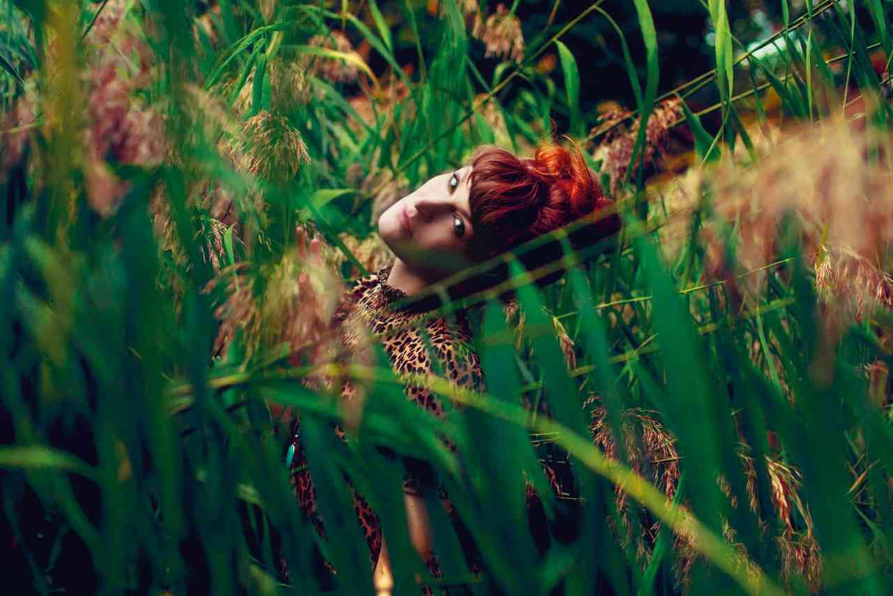 Das Bild zeigt Sängerin hinter Gräsern