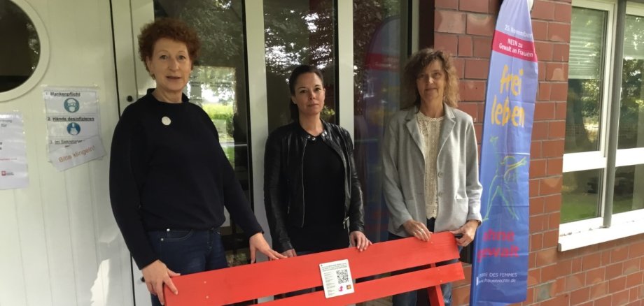 Edith Brefeld mit zwei Kolleginnen vor der roten Bank.