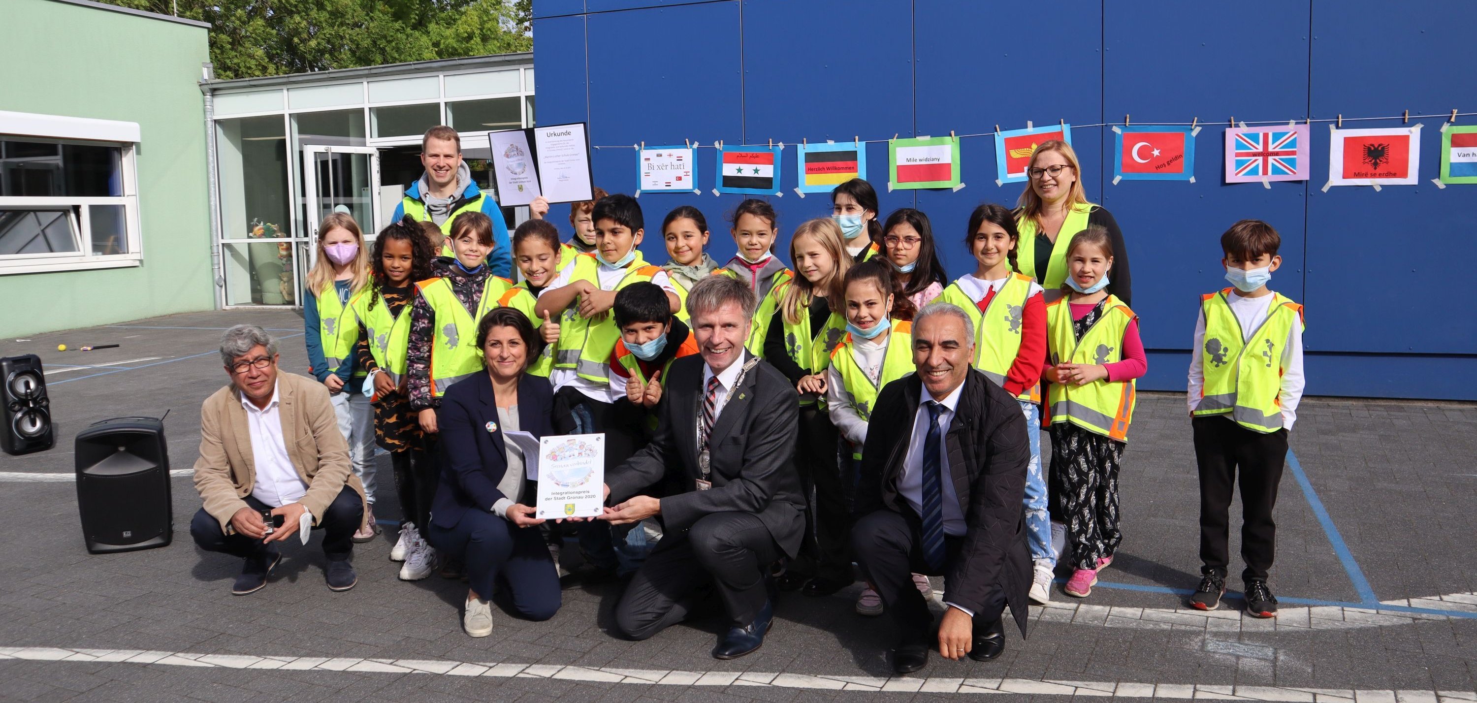 Herr Sezer (Stadt Gronau), Frau Aktan (Schulleiterin), Bürgermeister Doetkotte, Herr Savci (Integrationsrat Gronau) und die Professional Coaches und Junior Coaches freuen sich über den Integrationspreis. 