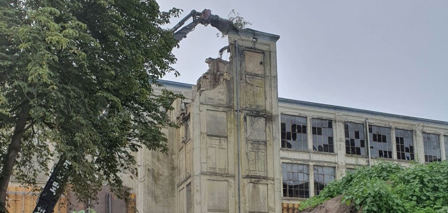 Ein Bagger reißt Stück für Stück den Nordturm ab.