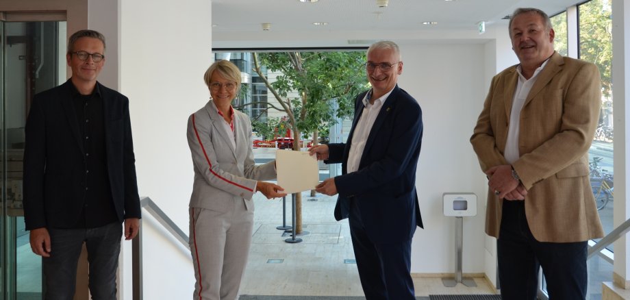 Regierungspräsidentin Dorothee Feller (2.v.l.) überreicht im Beisein von Stephan Kemper (l.) und Ulrich von Bruchhausen (r.) (Städtebaudezernat der Bezirksregierung Münster) den Förderbescheid an Gronaus Stadtbaurat Ralf Groß-Holtick (2.v.r.) 