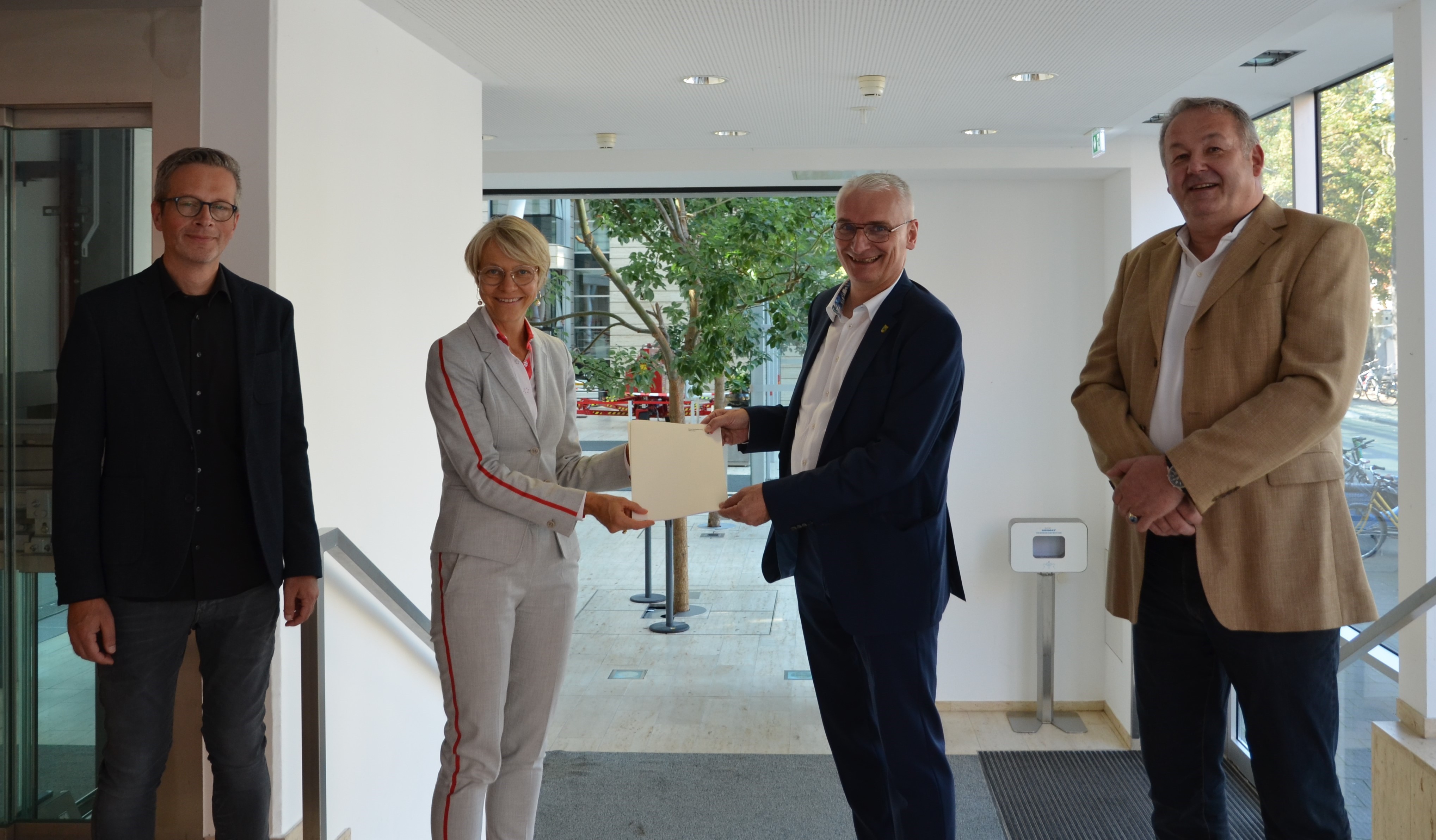 Regierungspräsidentin Dorothee Feller (2.v.l.) überreicht im Beisein von Stephan Kemper (l.) und Ulrich von Bruchhausen (r.) (Städtebaudezernat der Bezirksregierung Münster) den Förderbescheid an Gronaus Stadtbaurat Ralf Groß-Holtick (2.v.r.) 