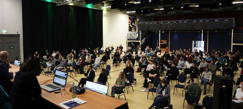Die Studierenden sitzen in der Bürgerhalle und hören den Vorträgen zu.