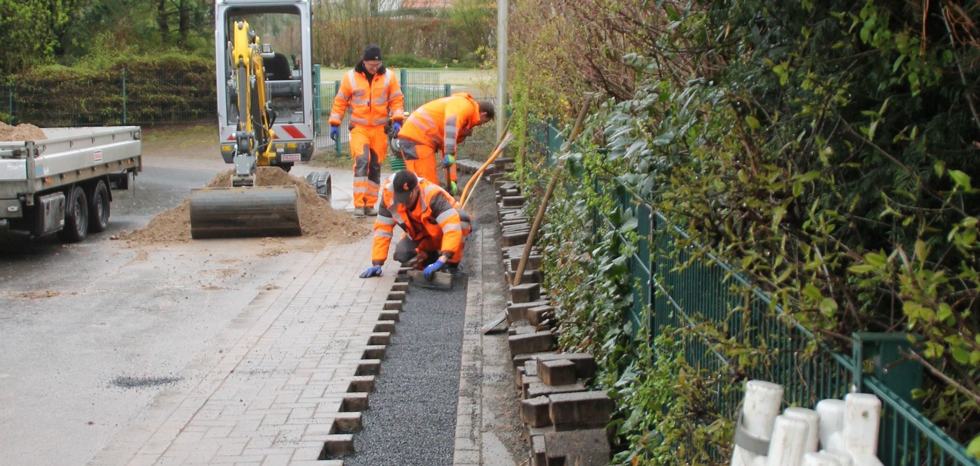 Bauarbeiter schließen den Fußweg nach Glasfaserarbeiten.