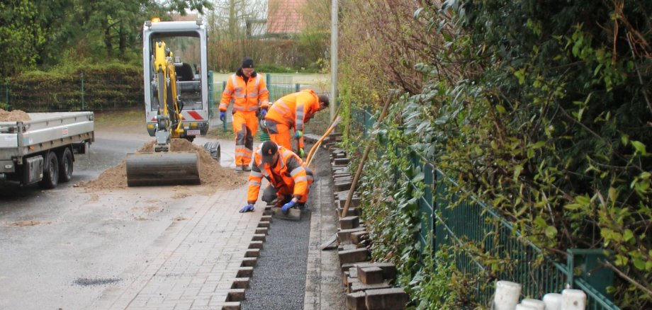 Bauarbeiter schließen den Fußweg nach Glasfaserarbeiten.