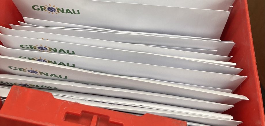 Zahlreiche Wahlbriefe in einer roten Kiste