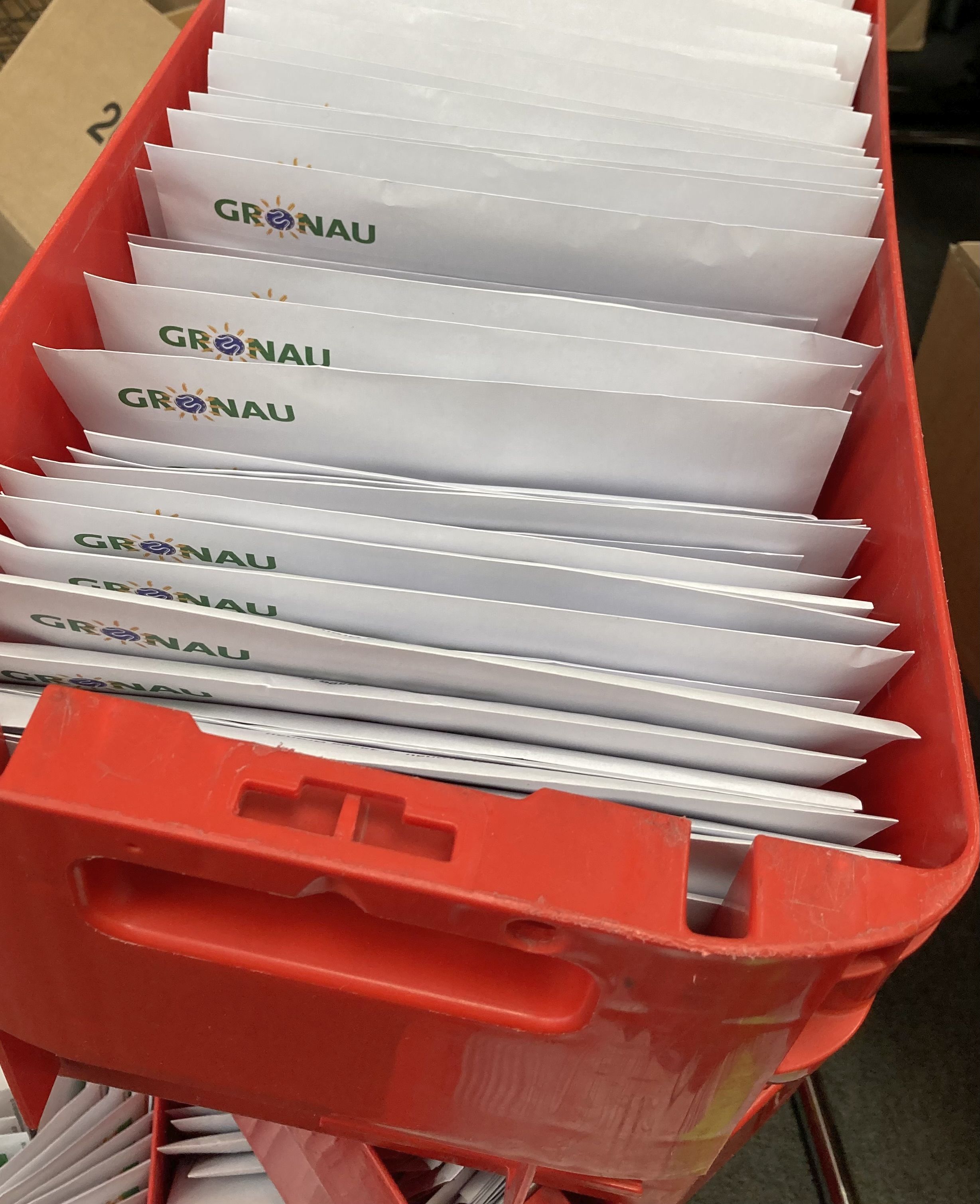 Zahlreiche Wahlbriefe in einer roten Kiste